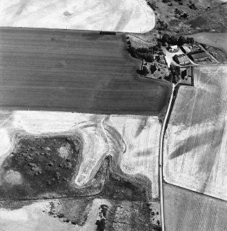 Gilchrist, oblique aerial view, taken from the WNW, centred on the cropmarks of a promontory fort. Kilchrist Church is visible in the top right-hand corner of the photograph.