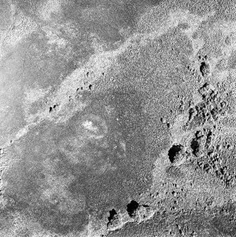 Oblique aerial view of Garbeg centred on the remains of a hut-circle in an area of hut-circles, small cairns, a field-system and rig, taken from the SSW.