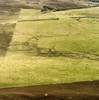 Oblique aerial view of Garbeg centred on the remains of hut-circles, buildings, field-systems and small cairns, taken from the WNW.
