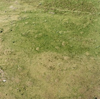 Oblique aerial view of Garbeg centred on the remains of hut-circles, small cairns and a field-system, taken from the E.