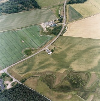 Oblique aerial view centred on the cropmarks of the possible pit-defined enclosure, pits, linear cropmarks and promontory fort, taken from the W.