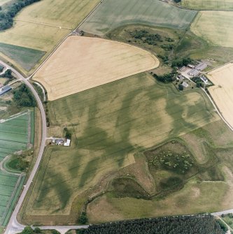 Oblique aerial view centred on the cropmarks of the possible pit-defined enclosure, pits, linear cropmarks and promontory fort with church, mausoleum and cemetery adjacent, taken from the WNW.