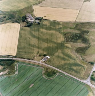 Oblique aerial view centred on the cropmarks of the possible pit-defined enclosure, pits, linear cropmarks and promontory fort with church, mausoleum and cemetery adjacent, taken from the N.