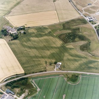 Oblique aerial view centred on the cropmarks of the possible pit-defined enclosure, pits, linear cropmarks and promontory fort with church, mausoleum and cemetery adjacent, taken from the NE.