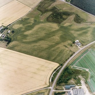 Oblique aerial view centred on the cropmarks of the possible pit-defined enclosure, pits, linear cropmarks and promontory fort with church, mausoleum and cemetery adjacent, taken from the ENE.