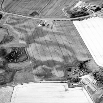 Oblique aerial view centred on the cropmarks of the possible pit-defined enclosure, pits, linear cropmarks and promontory fort with church, mausoleum and cemetery adjacent, taken from the SSW.