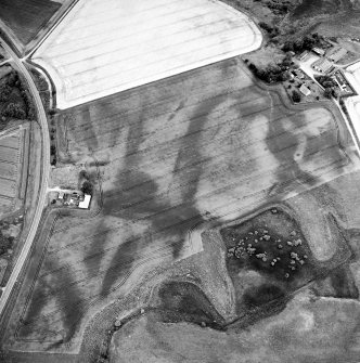 Oblique aerial view centred on the cropmarks of the possible pit-defined enclosure, pits, linear cropmarks and promontory fort with church, mausoleum and cemetery adjacent, taken from the WNW.