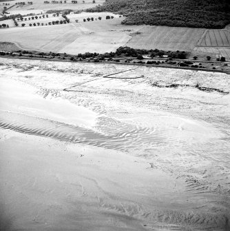 Oblique aerial view centred on the remains of the fish trap, taken from the NW.