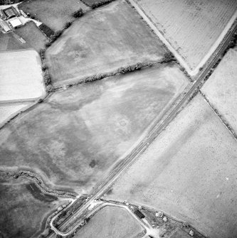 Oblique aerial view centred on the cropmarks of the pit-circles and ring-ditch, taken from the WSW.