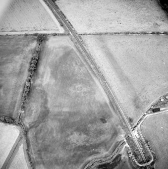 Oblique aerial view centred on the cropmarks of the pit-circles and ring-ditch, taken from the NW.