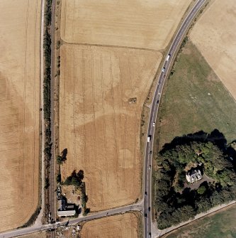 Culloden, oblique aerial view, taken from the SW, centred on a pit-alignment and other cropmarks and the remains of a chambered cairn. Culloden railway station is visible in the bottom left-hand corner of the photograph.