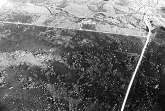General oblique aerial view centred on the remains of the sheepfold and the hut-circles, taken from the NNW.