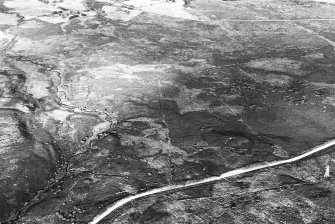 General oblique aerial view centred on the remains of the enclosures and farmstead, taken from the W.