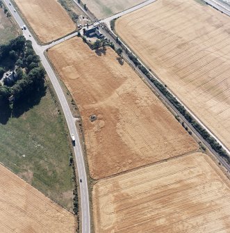 Culloden, oblique aerial view, taken from the E, centred on a pit-alignment and other cropmarks and the remains of a chambered cairn. Culloden railway station is visible in the centre top half of the photograph.