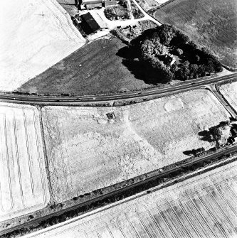 Culloden, oblique aerial view, taken from the NNW, centred on a pit-alignment and other cropmarks and the remains of a chambered cairn. Culloden railway station is visible in the centre right half of the photograph.