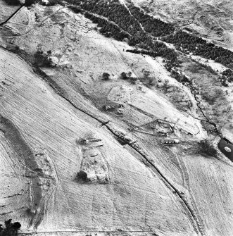 Ballourie, oblique aerial view, taken from the E, showing the remains of a township across the photograph, and rig in the foreground.