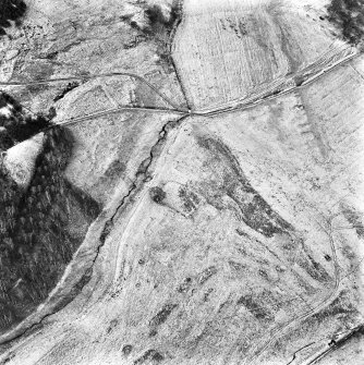 Ballourie, oblique aerial view, taken from the SW, centred on the remains of a township, buildings, banks and an enclosure.