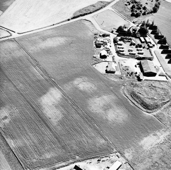 Mains of Gartan, oblique aerial view taken from the N, centred on the remains of a motte and the cropmark of a possible enclosure.  The Mains of Garten is visible in the top right hand corner of the photograph.