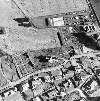 Oblique aerial view centred on the church and churchyard with excavation adjacent, taken from the NNW.