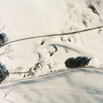 Oblique aerial view of Peel of Fichlie centred on the remains of a motte-and-bailey castle, taken from the SSE.