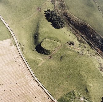 Oblique aerial view of Peel of Fichlie centred on the remains of a motte-and-bailey castle, taken from the WNW.