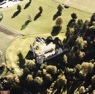 Oblique aerial view of Kildrummy castle centred on the remains of the castle, taken from the N.