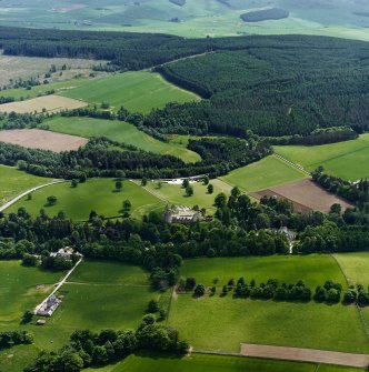 Oblique aerial view centred on the remains of the castle with hotel, farmhouse and farmsteading adjacent, taken from the NW.