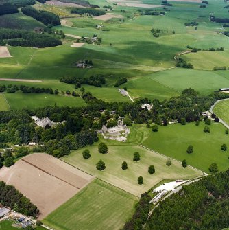 Oblique aerial view centred on the remains of the castle with hotel, farmhouse and farmsteading adjacent, taken from the SSE.