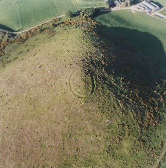 Oblique aerial view centred on the remains of the fort with the remains of the cottage, huts and sheepfold adjacent, taken from the SW.