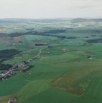 General Oblique aerial view looking across the village with the remains of the vitrified fort in the distance, taken from the SSE.