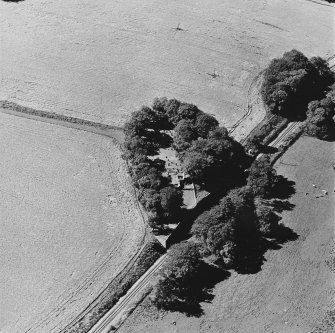 Oblique aerial view of Kennethmont centred on St Alkmund's Parish Church and burial-ground, taken from the ENE.