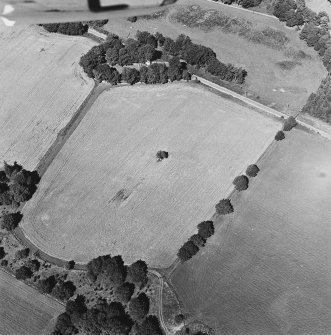 Oblique aerial view of Kirkhill centred on the cropmarks of a manse and possible ring-ditches, with a church and burial-ground adjacent, taken from the SE.