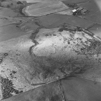 Oblique aerial view of White Hill centred on the remains of the enclosure and quarries with farmhouse adjacent, taken from the SE.