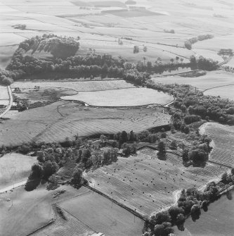 Oblique aerial view of Wardhouse Home Farm, centred on the remains of rig, small cairns and farmstead with hut-circles, small cairns, rig, cottages and quarry adjacent, taken from the NE.