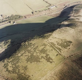 Oblique aerial view of Hill of Christ's Kirk centred on the remains of fort and rig with mill and farmhouse adjacent, taken from the SW.