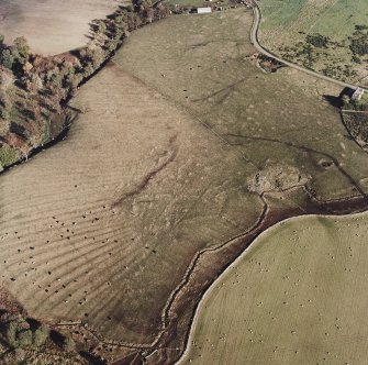 Oblique aerial view of Wardhouse Home Farm centred on the remains of rig, small cairns and farmstead with hut-circles, small cairns and quarry adjacent, taken from the NW