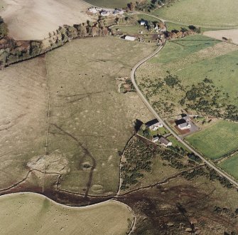 Oblique aerial view of Wardhouse Home Farm centred on the remains of hut-circles, small cairns and rig with rig, cairns, field-system, quarry and cottage adjacent, taken from the W.