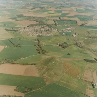 Oblique aerial view centred on the remains of the fort with village adjacent, taken from the W.