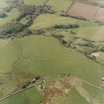 Oblique aerial view centred on the remains of the rig, small cairns, hut-circles and quarry, taken from the SE.