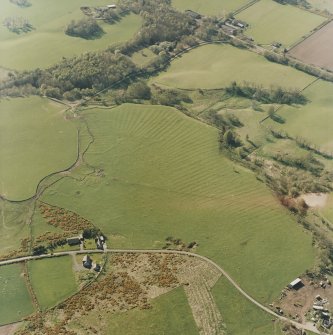 Oblique aerial view centred on the remains of the rig, small cairns, hut-circles and quarry, taken from the ESE.