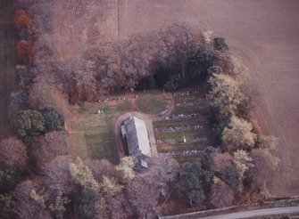 Oblique aerial view centred on the remains of the recumbent stone circle, the church and burial-ground, taken from the W.