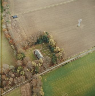 Oblique aerial view centred on the remains of the recumbent stone circle, the church and burial-ground, taken from the WNW.