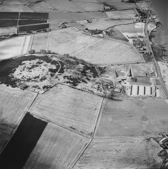 Oblique aerial view centred on the enclosure and Archaeolink visitor centre taken from the E.