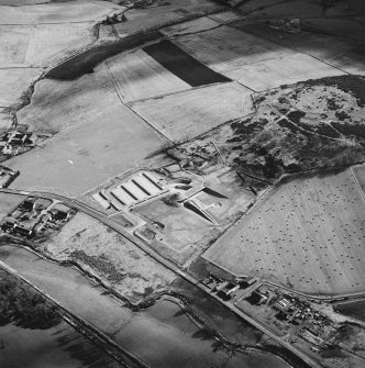 Oblique aerial view centred on the enclosure and Archaeolink visitor centre taken from the NNW.