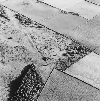 Oblique aerial view of Templefold centred on the remains of rig, with hut-circles and small cairns adjacent.  Taken from the NW.