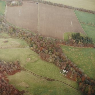 Oblique aerial view centred on the remains of the motte with the church and burial-ground adjacent, taken from the S.
