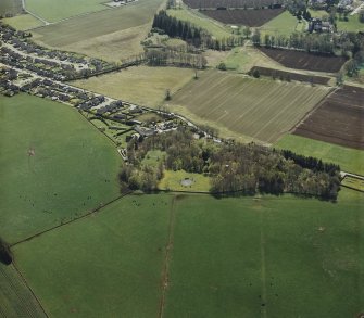 Oblique aerial view centred on the remains of the recumbent stone circle and enclosed cremation cemetery, taken from the NE.