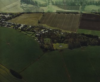 Oblique aerial view centred on the remains of the recumbent stone circle and enclosed cremation cemetery, taken from the NE.