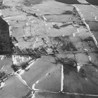 Oblique aerial view of the remains of rig, hut-circle, small cairns and quarries taken from the NNE.