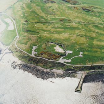 Oblique aerial view centred on the remains of the coastal battery with breakwaters adjacent, taken from the N.
